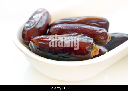 Macro of date fruits in a plate on white background Stock Photo