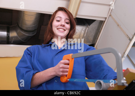 Woman using a hacksaw Stock Photo