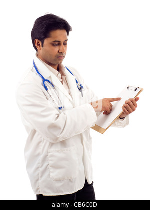 Young Asian medical doctor pointing at blank clipboard ad space isolated over white background Stock Photo