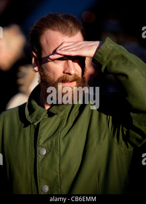 Bearded man blinded by the sun covering his eyes with hand as a visor. Stock Photo