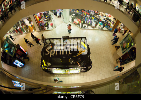 Shoppers pass a Sprint kiosk at a mall in the borough of Queens in New York Stock Photo