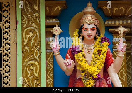 Garlanded Vishnu statue on a colourful Hindu Hanuman temple. Andhra Pradesh, India Stock Photo