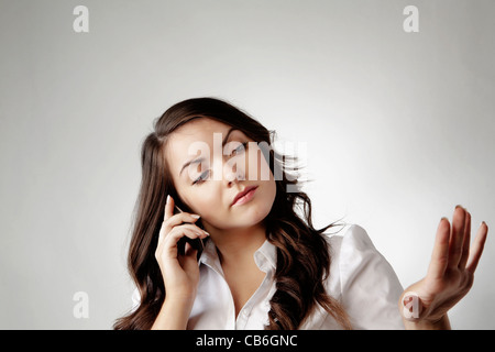 young woman on moblie telephone looking at her nails and talking Stock Photo