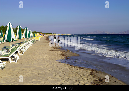 Young couple walking hand in hand along a deserted Beach at Tingaki early morning Kos Stock Photo