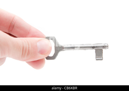 Male hand holding a key to the house, image is taken over a white background. Stock Photo