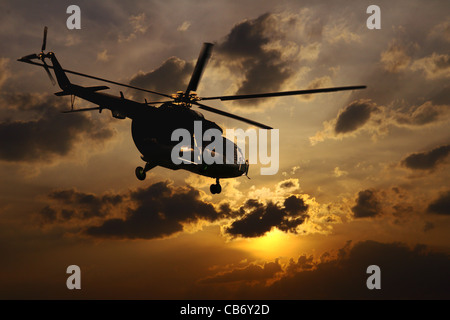 Helicopter landing at sunset Stock Photo