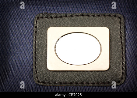 Metal Plate, with black border  inserted in blue fabric Stock Photo