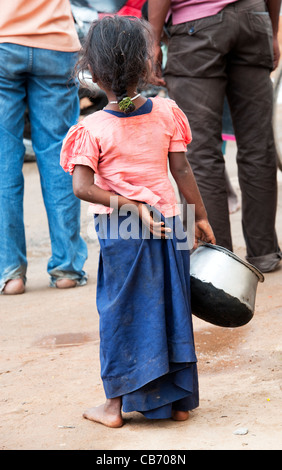 Poor Indian nomadic beggar girl on an indian street begging from behind. Andhra Pradesh, India. Stock Photo