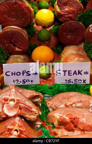 Photo of raw cuts of meat in a butchers shop including beef and veal steaks, chops and joints. Stock Photo