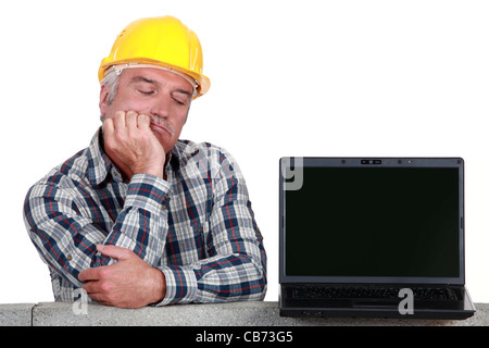 senior craftsman posing next to a laptop Stock Photo