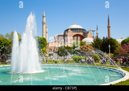 Turkey, Istanbul, Sultanahmet, Haghia Sophia with dome and minarets beyond the water fountain in the gardens with tourists Stock Photo