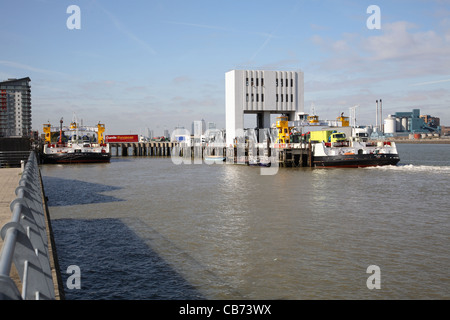 London's Woolwich Ferry leaves the south jetty fully loaded. Another out-of-service ferry in moored nearby Stock Photo