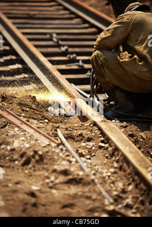 worker cutting through a railroad track , selective focus Stock Photo