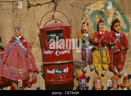 Traditional Rajasthani puppets for sale, hung on a wall next to a postbox, Jaisalmer, Rajasthan, India Stock Photo
