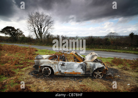 A burnt out Mazda MX5 on Dartmoor in Devon, UK. Stock Photo