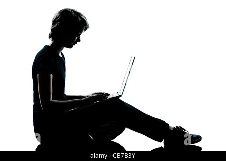 one caucasian young teenager silhouette boy girl computer computing laptop full length in studio cut out isolated on white background Stock Photo