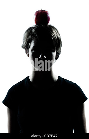 one caucasian young teenager silhouette boy or girl with an apple on his head portrait in studio cut out isolated on white background Stock Photo