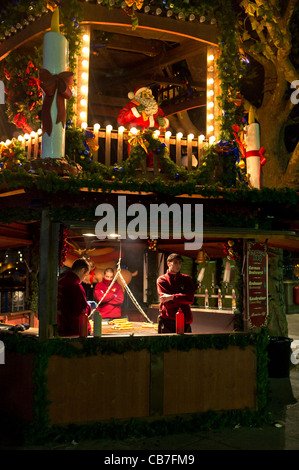 Male staff on a BBQ stall at a Christmas Market wait for custom. Stock Photo