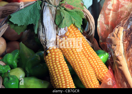 Three golden corncobs placed on other vegetables. Stock Photo