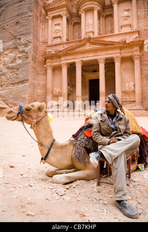 Camel driver waits for tourist / tourists in front of 'The Treasury': Al Khazneh / El Khazneh, at the lost city of Petra, Jordan Stock Photo