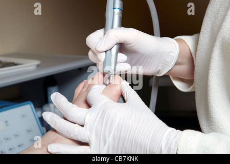 A podiatrist edit the toenails with a grinding machine Stock Photo - Alamy