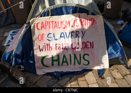 St Paul's Cathedral Tent City Occupy London activists banner Capitalism is a Kind of Slavery with Fake Golden Chains Stock Photo