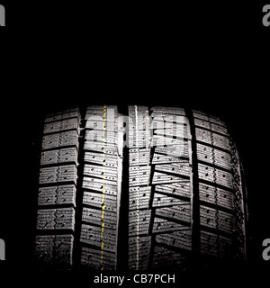 Part of brand new car tyre isolated on a black background. Square format.