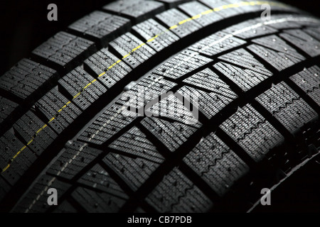 Part of brand new car tyre. Shallow DOF. Black back background. Stock Photo