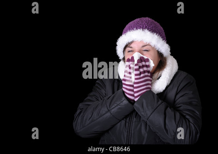 young woman having blowing her nose. Isolated on black Stock Photo
