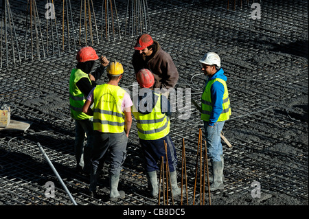 Construction workers chatting while on a break at a construction site Stock Photo