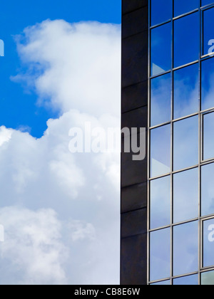 Modern glass office block window with cloud and sky reflected in the glass Stock Photo