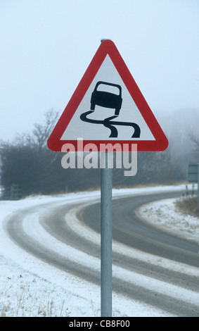 warning sign of slippery road in winter snow near Leeds Yorkshire UK Stock Photo