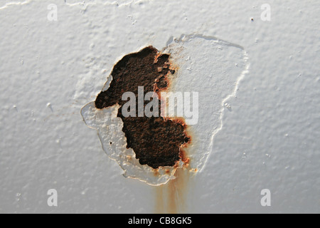 peeling rust spot on a white painted steel tank Stock Photo