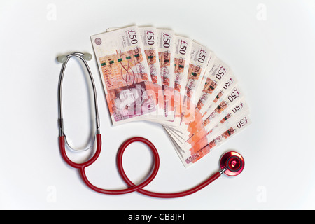 Stethoscope resting on top of cash new £50 pound bank notes Stock Photo