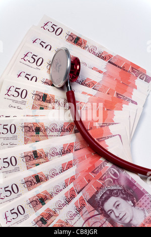 Stethoscope resting on top of cash new £50 pound bank notes Stock Photo