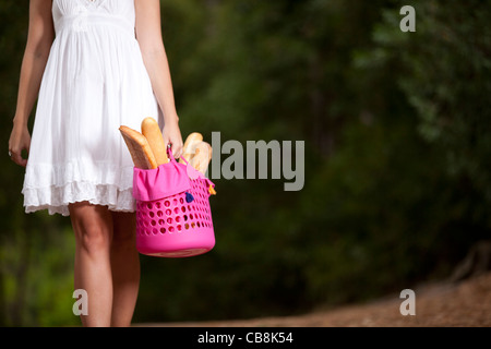 young woman in the woods with a basket full of bread Stock Photo