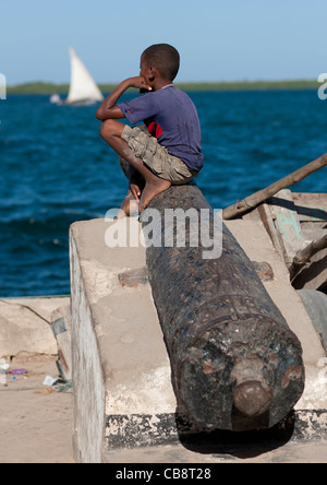 Cannon And Dreamy Boy on A Dockside of Lamu Kenya Stock Photo