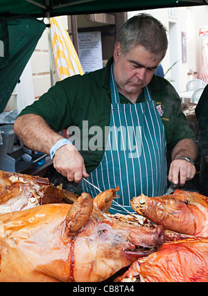 Man carving roast pig Abergavenny Food Festival Wales UK Stock Photo