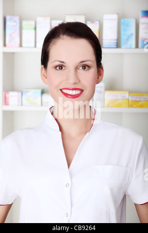 Pretty caucasian smiling pharmacist wearing white uniform. Stock Photo