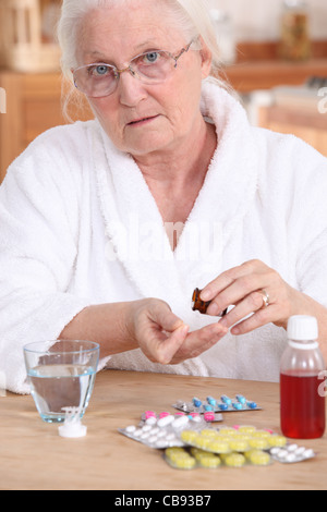 Older woman taking medicine Stock Photo