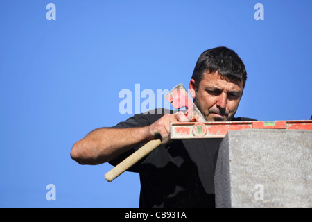 Tradesman using an axe and a bubble level Stock Photo
