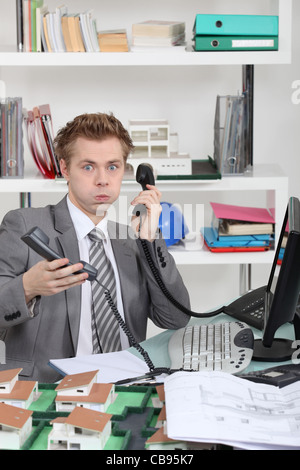 young man overwhelmed with phone calls Stock Photo
