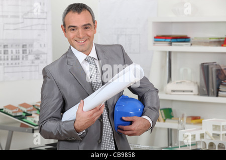 Architect with plans and hardhat Stock Photo