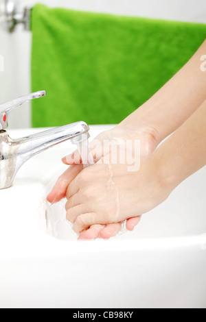 Hands closeup while being washed in the basin. Stock Photo