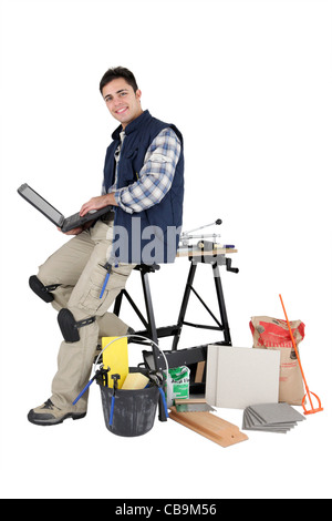 Tiler with computer, studio shot Stock Photo