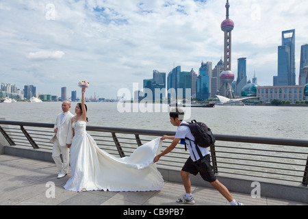 Chinese wedding bride and groom on the Bund waterfront posing in front of the Oriental pearl building Shanghai PRC China Asia Stock Photo