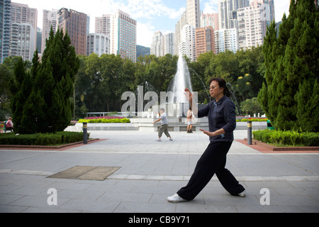 chinese woman performing tai chi in the hong kong zoological and botanical gardens hong kong island hksar china Stock Photo