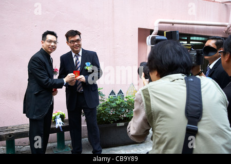 chinese bridegroom with lucky red and gold money envelopes giving to guest and having photos taken on his wedding day hong kong Stock Photo