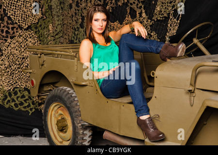 A young Caucasian woman amongst military memorabilia Stock Photo