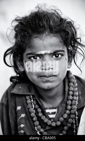 Poor Indian beggar girl with prayer beads, staring. Selective focus Black and White Stock Photo